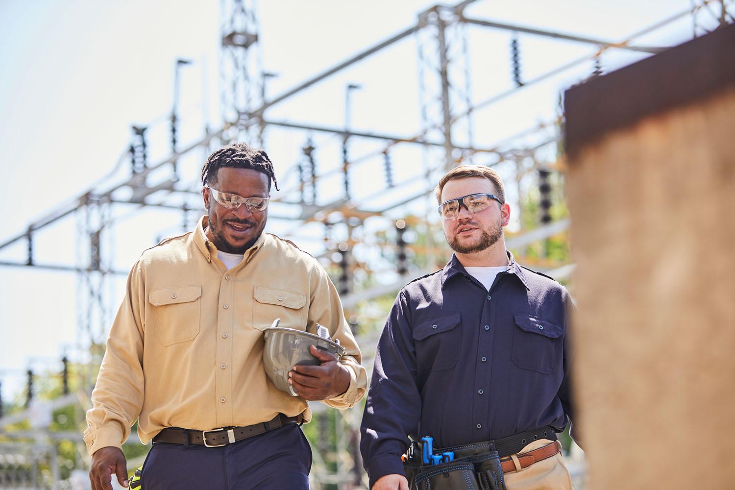 Two electrical contractors walking to work in DH shirts.